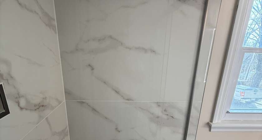 clean white marble tile shower with sealed grout by Bathroom Bidders Kansas City