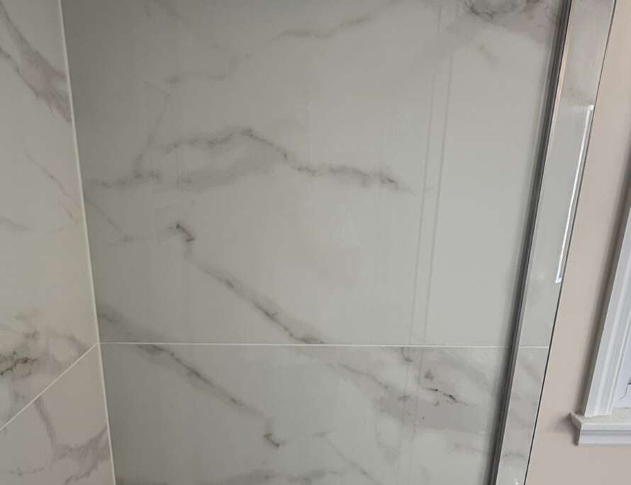clean white marble tile shower with sealed grout by Bathroom Bidders Kansas City