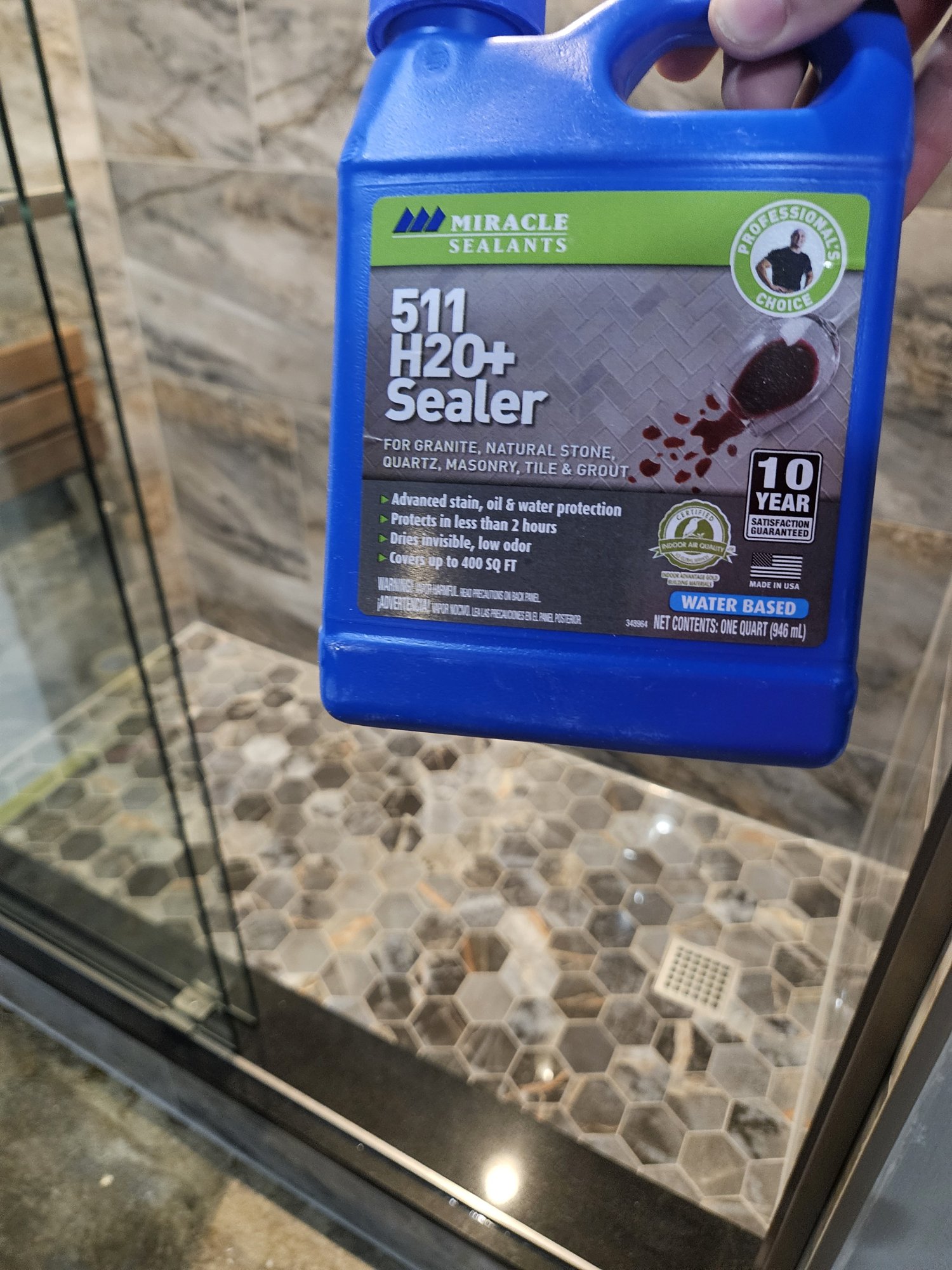 Sealing the grout on the new hex mosaic shower floor before handoff